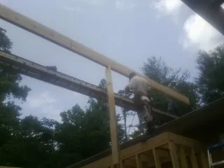 Carpenter setting a ridge beam over a new addition frame — Ice Dam Removal by Roofing Brothers in New Vernon