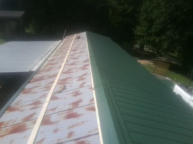Old rusted panels beside newly installed green metal roofing — Wind Damage Roof Repair by Roofing Brothers in New Vernon