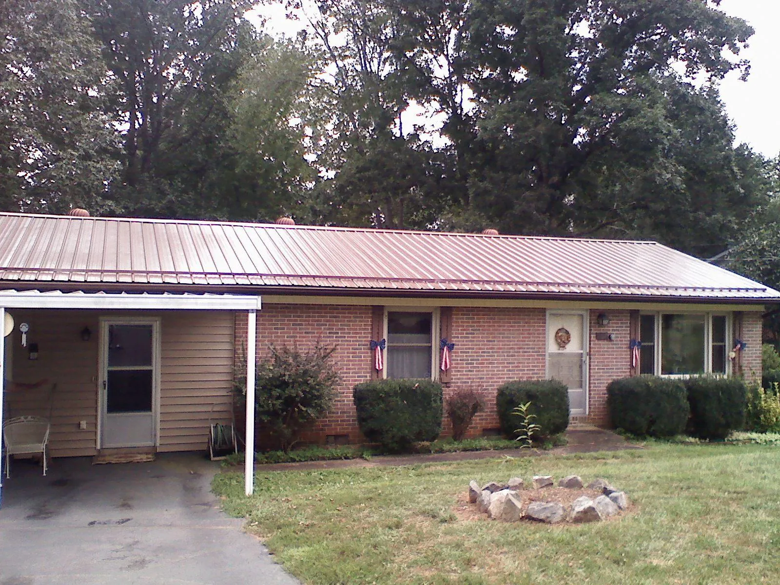 Bronze metal roof and carport on a brick ranch home — Roof Repair work by our crew in New Vernon