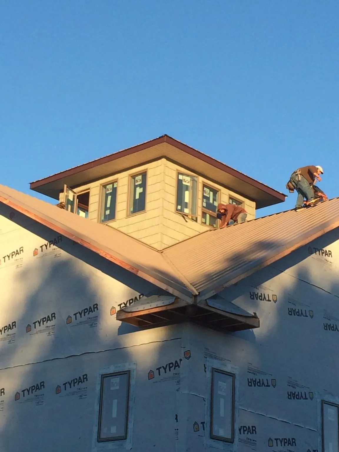 Roofers working around a rooftop cupola on a new metal roof at sunset — Roof Waterproofing in New Vernon by Roofing Brothers